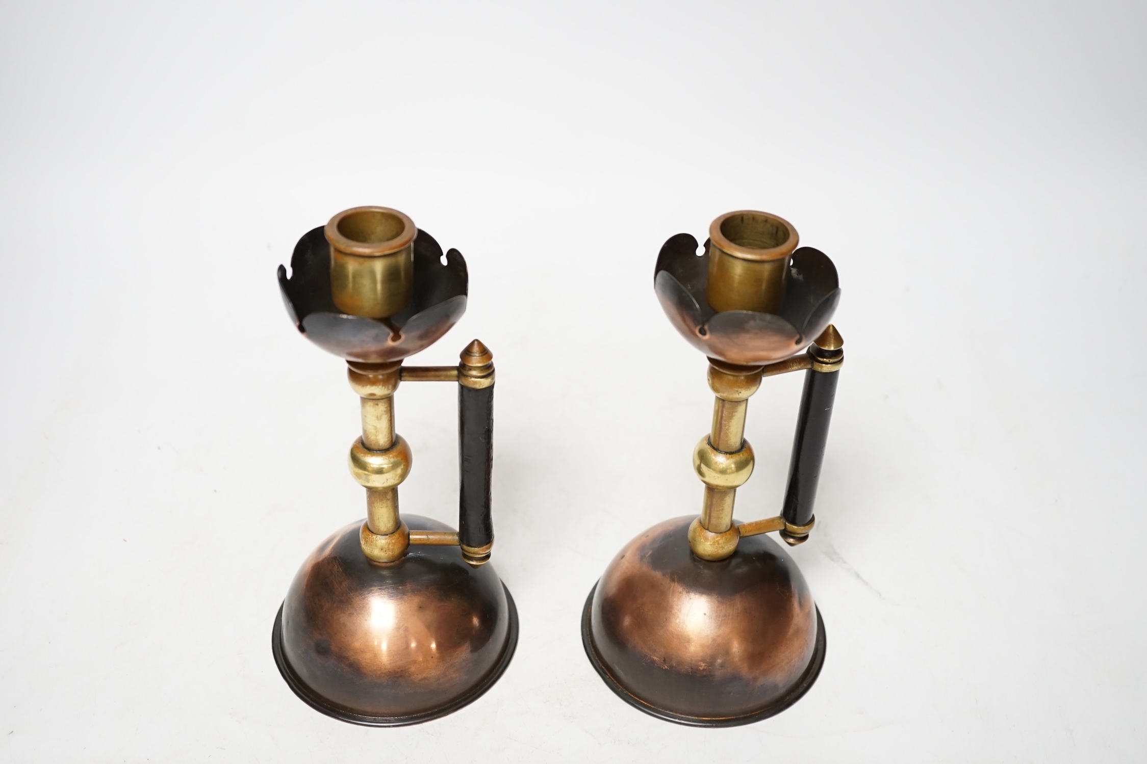 Christopher Dresser, a pair of copper and brass candlesticks by Benham and Froud, 18.5cm. Condition - fair
